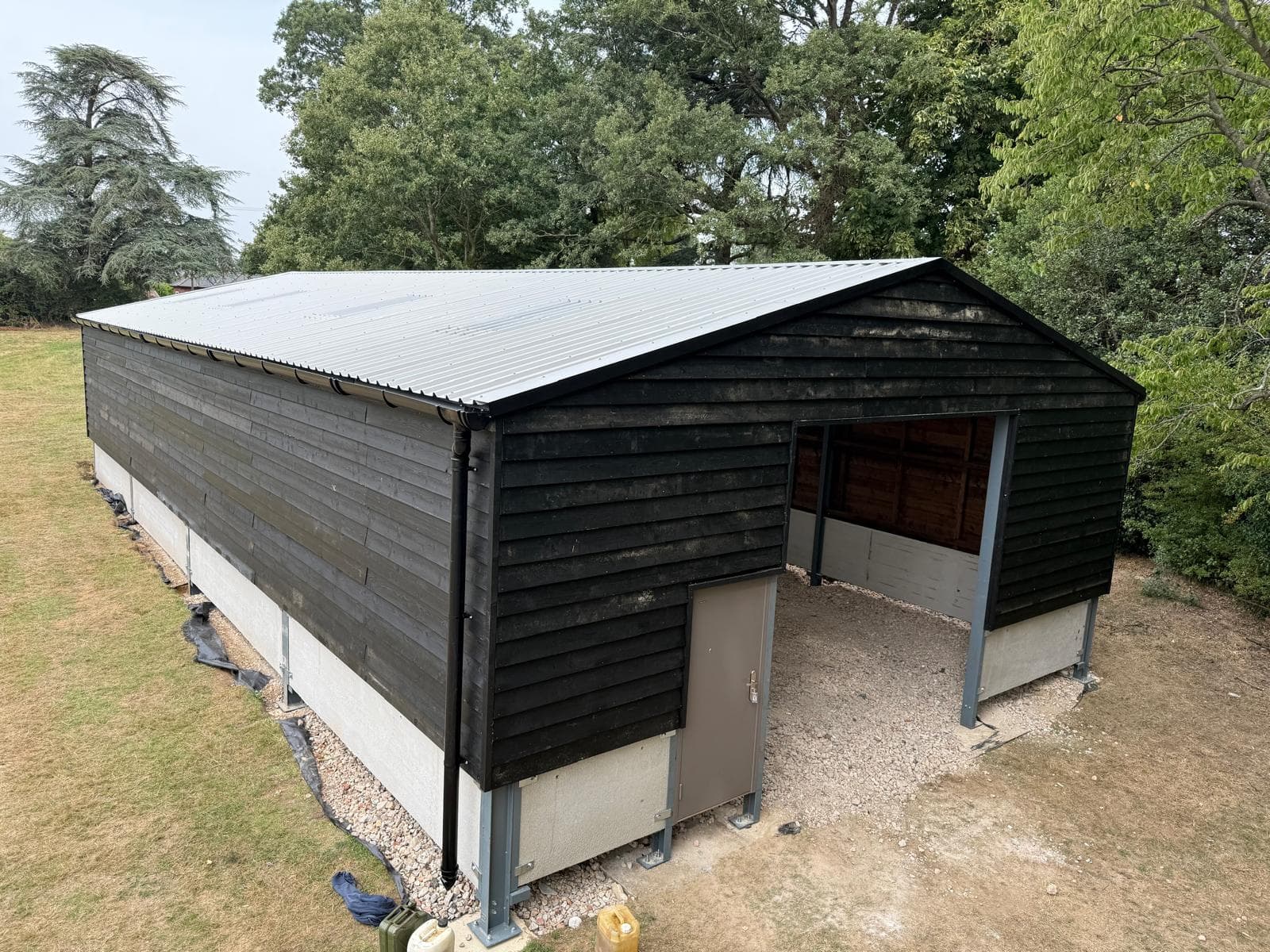Completed black-clad agricultural building with open front access